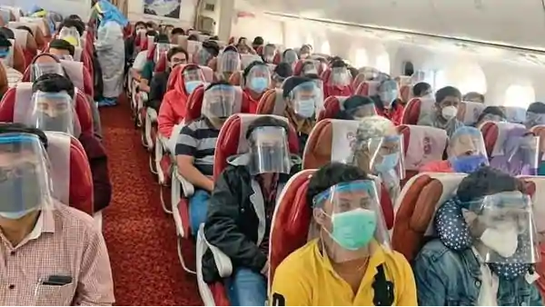 Indian expats aboard the Singapore-Mumbai flight wear face shields on Sunday.
