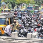 Two-wheelers and autorickshaws parked on the roadside at Menaka Junction in the city