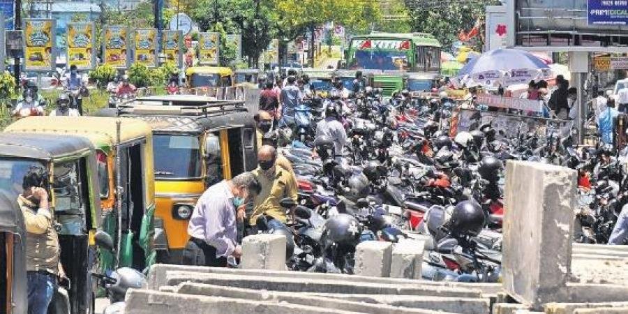 Two-wheelers and autorickshaws parked on the roadside at Menaka Junction in the city