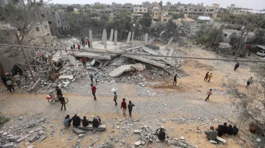 Palestinians inspect the site of an Israeli strike on a hous in Khan Younis in the southern Gaza Strip on Friday.