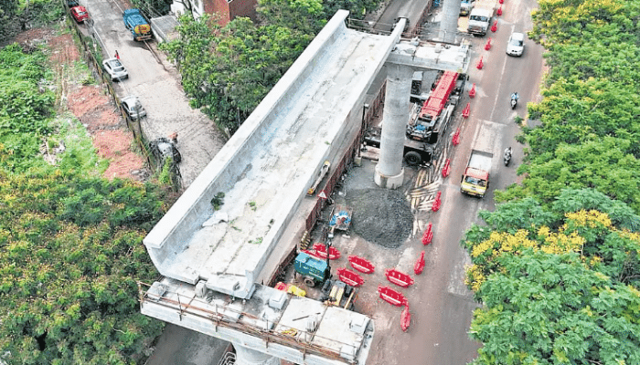 Workers installing a U-girder on the Kochi Metro Pink Line viaduct