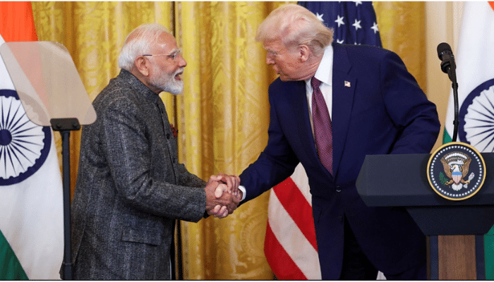 Donald Trump and PM Narendra Modi shaking hands during a diplomatic meeting, smiling and discussing bilateral relations.